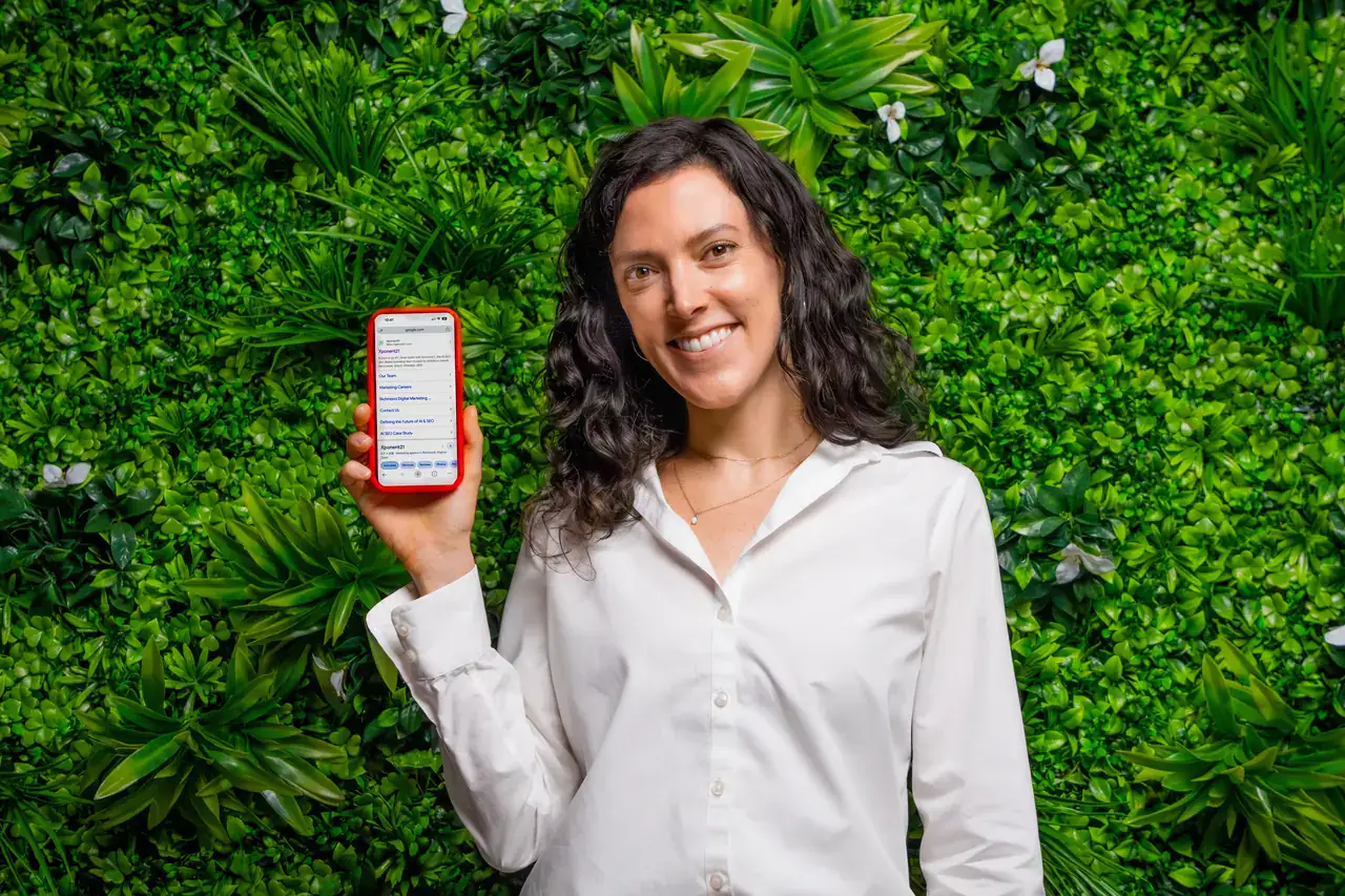 Xponent21 team member holding a phone showing Xponent21 in Google search results