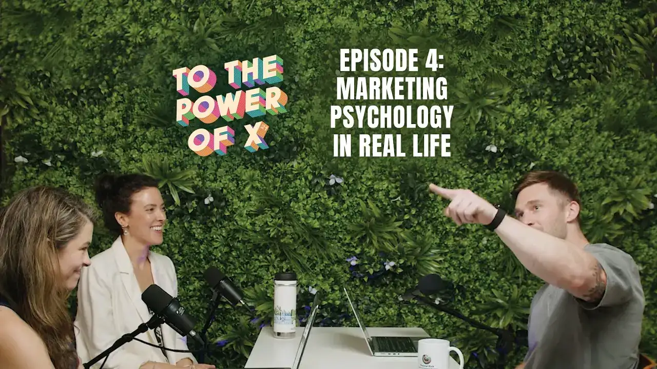 three people sitting around a table recording a podcast